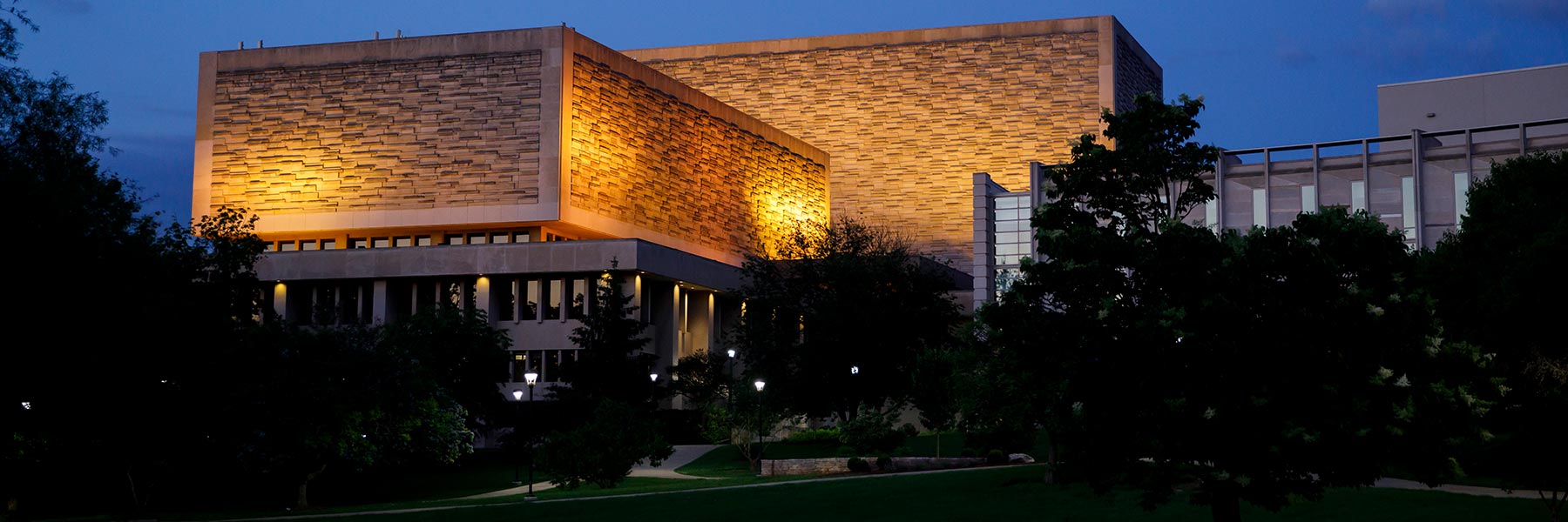 View of arboretum and Herman B Wells Library lit at night.