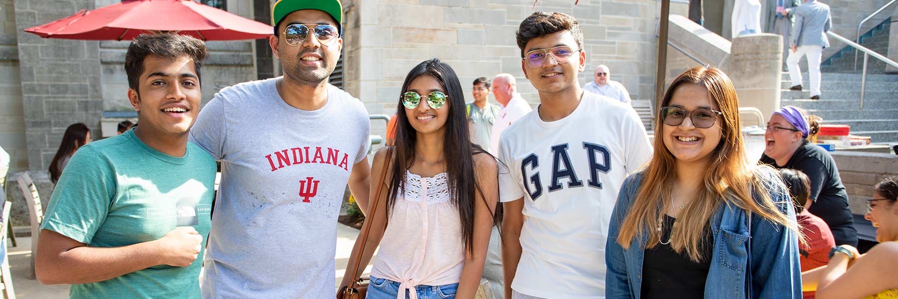 Five students stand outside the Memorial Union during a social event.